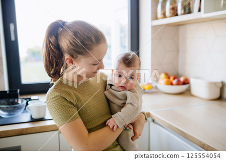 Big sister holding in arms baby brother. 125554054