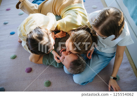 Portrait of father with three daughters at home. Portrait of father with three daughters at home. 125554062