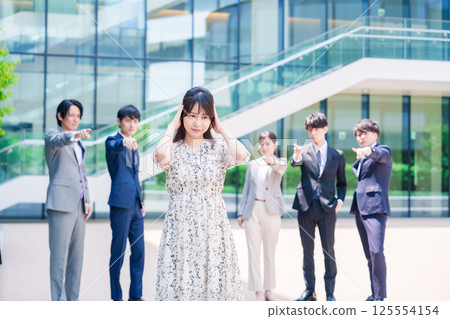 A female business person holding her head after being blamed by a colleague 125554154