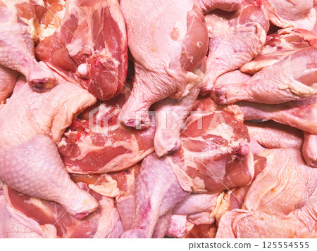 A detailed display of fresh raw chicken thighs perfect for supermarket promotions, butcher shop advertising, or content related to food preparation and cooking. 125554555