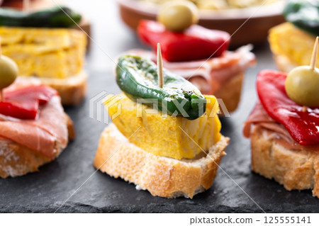 Traditional Spanish pintxos on wooden table 125555141