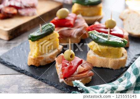 Traditional Spanish pintxos on wooden table 125555145