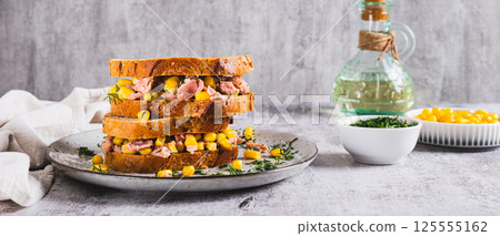 Delicious sandwiches with tuna, corn and greens on grain bread web banner 125555162