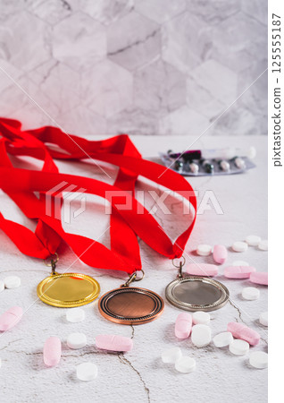 Concept of doping in sports, medals, pills and syringe on the table vertical view 125555187