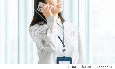 微笑的女人/女商人在智慧型手機上交談 125555644