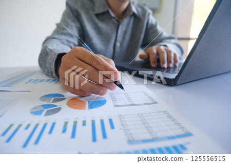 Professional businessman analyzing financial graphs investment marketing data. 125556515