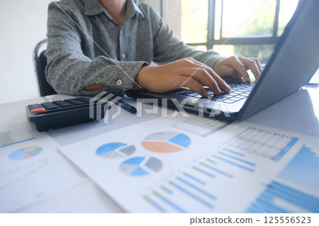 Professional businessman using computer laptop analyzing financial graphs investment marketing data. Professional businessman using computer laptop analyzing financial graphs investment marketing data. 125556523