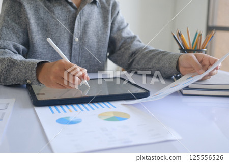 Professional businessman analyzing financial graphs investment marketing data. 125556526