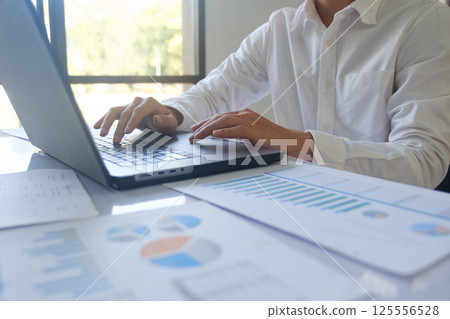 Professional businessman using computer laptop analyzing financial graphs investment marketing data. 125556528