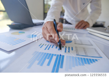 Professional businessman analyzing financial graphs investment marketing data. 125556533