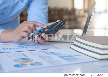 Close up accountant banker or bookkeeper making calculations with calculator. Close up accountant banker or bookkeeper making calculations with calculator. 125556545