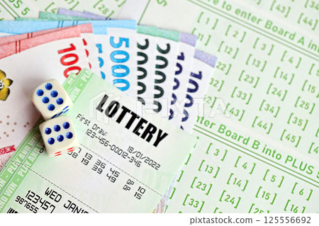 Green lottery tickets and indonesian money bills on blank with numbers for playing lottery Green lottery tickets and indonesian money bills on blank with numbers for playing lottery 125556692