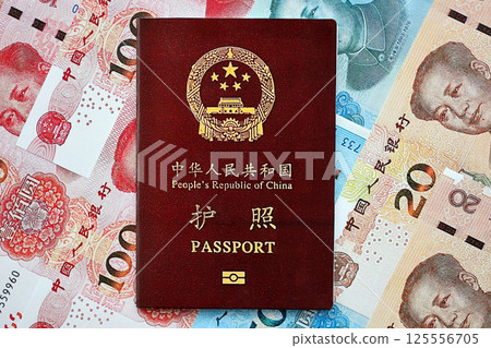 Red passport of People Republic of China and chinese yuan money bills. PRC chinese passport 125556705