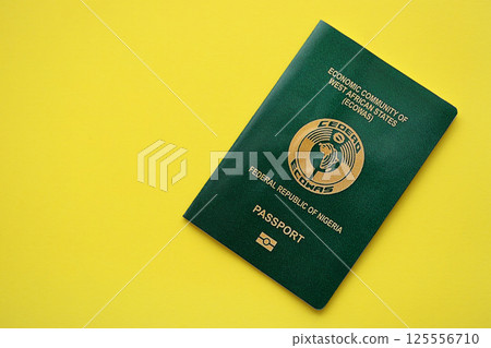 Green Nigerian passport on yellow background close up 125556710