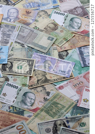 Many banknotes of different currency. Background of big amount of random money bills 125556717