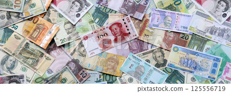 Many banknotes of different currency. Background of big amount of random money bills 125556719