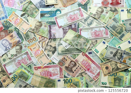 Many banknotes of different currency. Background of big amount of random money bills 125556720