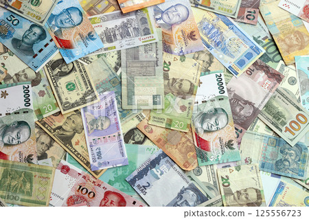 Many banknotes of different currency. Background of big amount of random money bills Many banknotes of different currency. Background of big amount of random money bills 125556723