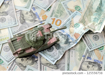 Tank on crumpled hundred dollar bills banknotes. Background of war funding and military support 125556738