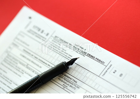 Indonesian tax form 1770 S - 2 Individual Income Tax Return and pen on table 125556742