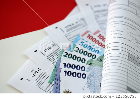 Indonesian tax forms 1770 Individual Income Tax Return and others with money on table Indonesian tax forms 1770 Individual Income Tax Return and others with money on table 125556753