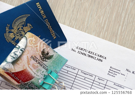 Kartu keluarga Family Identity Card with indonesian passport and bunch of indonesian rupiah bills 125556768