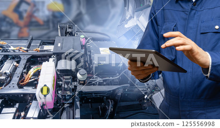 Serviceman with digital tablet next to electric truck. Electric vehicles maintenance 125556998