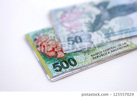 Argentine pesos money bills in big amount lies on white table close up 125557029