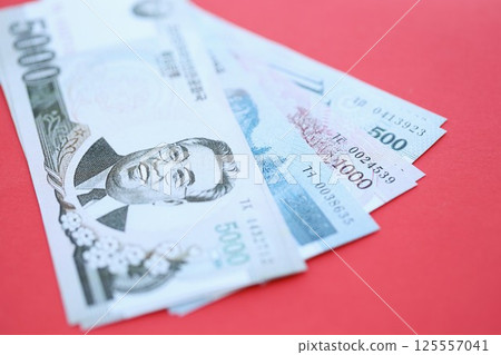 North Korean won money bills in big amount lies on red color table close up 125557041