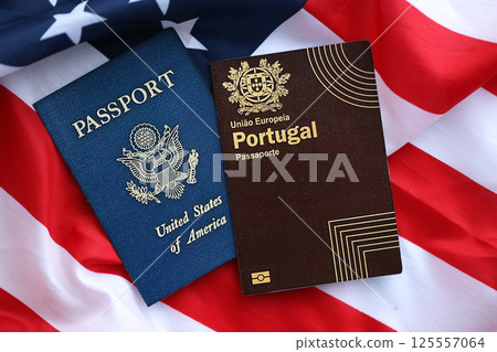 Passport of Portugal with US Passport on United States of America folded flag 125557064