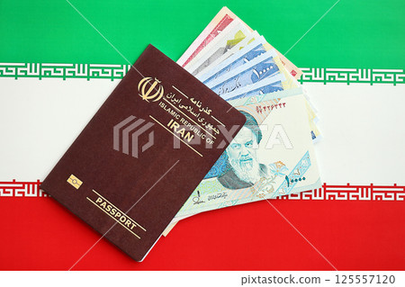 Red Islamic Republic of Iran passport and iranian reals money bills background close up Red Islamic Republic of Iran passport and iranian reals money bills background close up 125557120