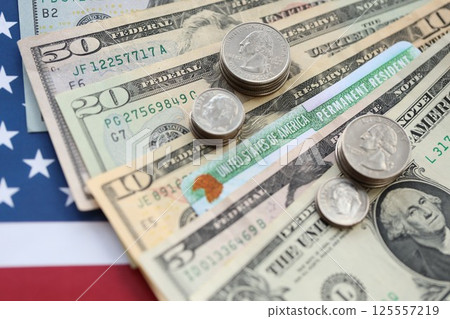 American US dollars money bills, green card on American flag close up 125557219