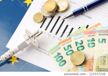 European union Euro money bills and coins with european electricity utility bill on table European union Euro money bills and coins with european electricity utility bill on table 125557230
