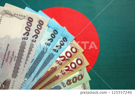 Bangladeshi taka money bills in big amount lies on Bangladesh flag close up Bangladeshi taka money bills in big amount lies on Bangladesh flag close up 125557240