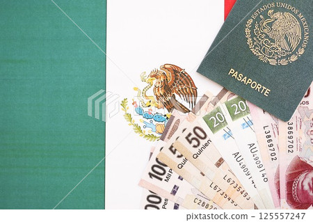 Mexican pesos money bills in big amount and passport lies on Mexico flag close up Mexican pesos money bills in big amount and passport lies on Mexico flag close up 125557247
