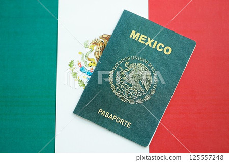 Mexican passport lies on Mexico flag close up. Travel and citizenship Mexican passport lies on Mexico flag close up. Travel and citizenship 125557248
