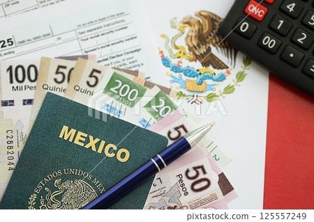 Mexican pesos money bills in big amount lies on table with pen, calculator, passport and tax forms Mexican pesos money bills in big amount lies on table with pen, calculator, passport and tax forms 125557249