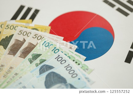 South Korean won money bills in big amount lies on South Korea flag close up South Korean won money bills in big amount lies on South Korea flag close up 125557252