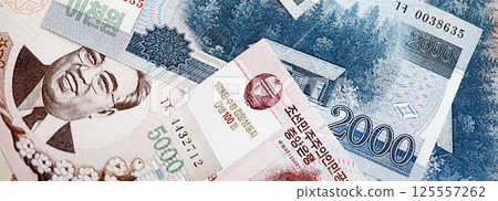 North Korean won money bills in big amount lies on white color table close up 125557262
