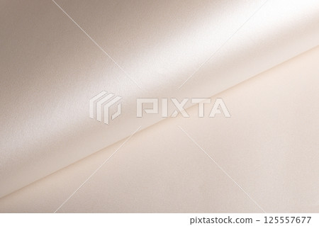 Background with satin paper texture. Rolled surface with glossy pearlescent finish, champagne and 125557677