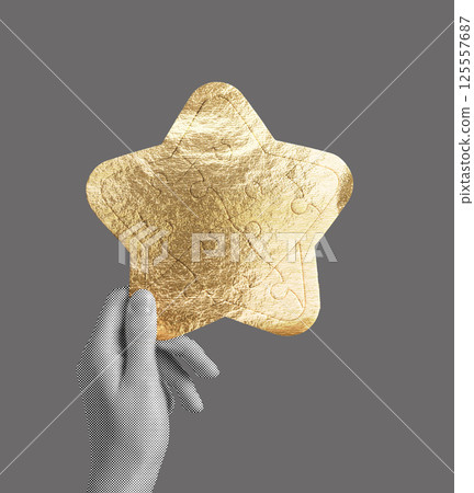Gold star puzzle piece held in hand, symbolizing achievement, success, and recognition. Luxury foil 125557687