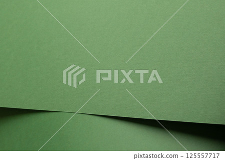 Paper background with matte texture. Folded layered sheets in pastel green, sage green, and subtle 125557717