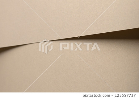 Paper background with matte texture. Layered smooth surface in beige and tan tones, warm pastel 125557737
