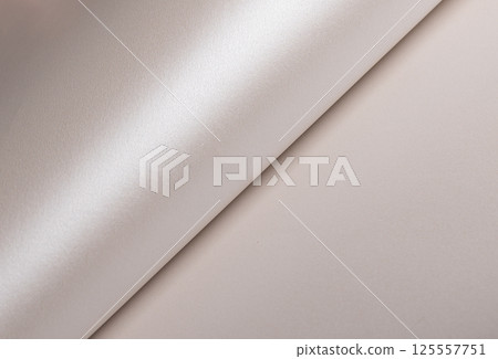 Paper background with satin pearlescent texture. Glossy curled folds, smooth surface in champagne 125557751