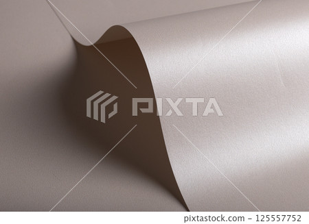 Paper background with satin pearlescent texture. Glossy curved folds, smooth sculptural surface in 125557752