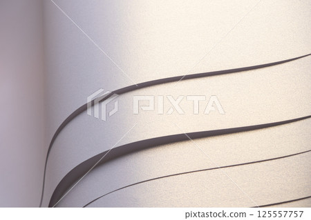 Paper background with satin pearlescent texture. Glossy folded wavy strips, layered surface in pale Paper background with satin pearlescent texture. Glossy folded wavy strips, layered surface in pale 125557757