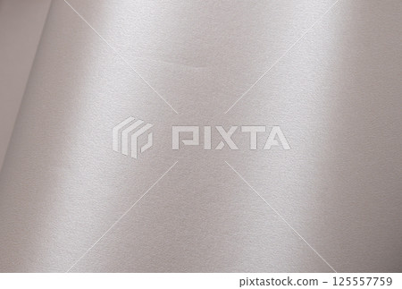 Paper background with satin pearlescent texture. Glossy smooth surface, soft champagne and pale gold 125557759