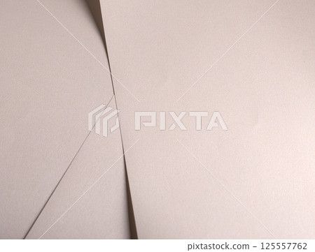 Paper background with satin pearlescent texture. Matte folded layers, smooth surface in pale gold Paper background with satin pearlescent texture. Matte folded layers, smooth surface in pale gold 125557762