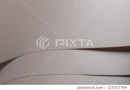 Paper background with satin pearlescent texture. Matte layered folds, smooth surface in pale gold Paper background with satin pearlescent texture. Matte layered folds, smooth surface in pale gold 125557764