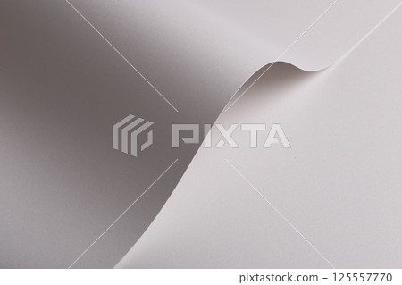 Pearl satin paper background with a glossy, smooth texture and graceful curved folds. Pale grey and 125557770